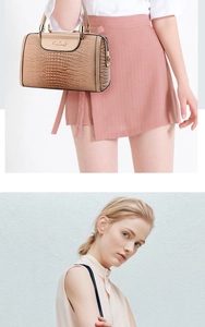 Detail of khaki crocodile pattern handbag with gold hardware and logo on model outfit