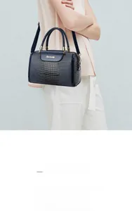 Detailed texture of dark blue crocodile pattern cowhide leather on a luxury handbag