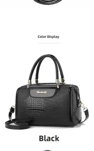 Close-up of glossy crocodile pattern faux leather and gold metal logo on black handbag