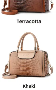 Detail view of khaki and earthy yellow croc-embossed leather handbags with gold hardware