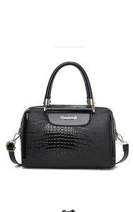 Detail of black crocodile texture handbag featuring golden metal handles and logo