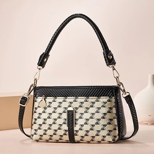 Detailed view of the patterned crossbody bag with snake print handle and gold hardware