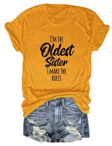 Mise à plat du t-shirt moutarde I'M THE OLDEST SISTER avec un short en jean déchiré