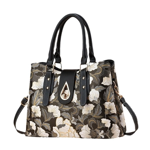 Elegante borsa a mano con stampa floreale bianca e nera, manici in pelle e chiusura oro
