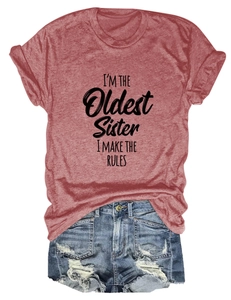 Détail du t-shirt rouge brique avec texte imprimé et short en jean bleu déchiré