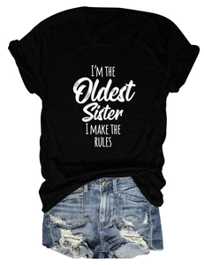 Détail de l'imprimé slogan sur le t-shirt noir et le short en jean bleu avec déchirures