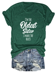 Gros plan du t-shirt vert foncé avec texte I'M THE OLDEST SISTER et short denim