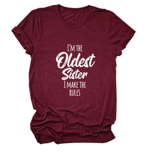 Détail des manches retroussées et de l'imprimé blanc sur le t-shirt bordeaux décontracté