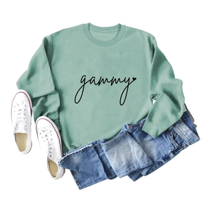 Detailed flat lay of a soft sage green sweatshirt featuring gammy heart print and denim shorts