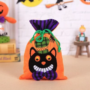 Close-up of velvet Halloween candy bag with black cat print and green drawstring detail