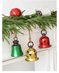 Close-up of metal Christmas bells with heart cut-outs and Merry Christmas ornaments