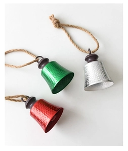Detail of red, green, and silver hammered metal Christmas bells with rustic hemp ropes
