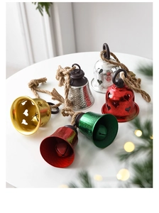 Close-up of colorful heart-shaped cutout metal bells with rustic jute twine hangers