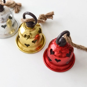 Three metal Christmas bells in red gold and silver with heart cutouts and hemp ropes