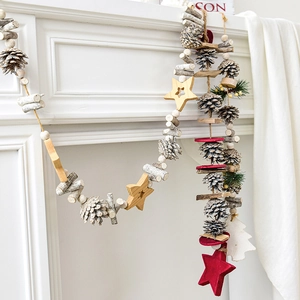 Christmas pine cone garland with wooden stars and red felt accents on white fireplace