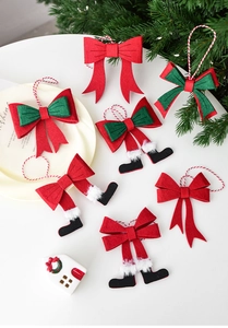 Detail of felt Christmas bow ornaments with Santa legs on a festive white background
