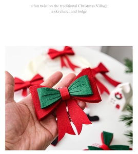 Detail of red and green layered felt Christmas bow ornament held against a festive background