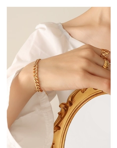 Detail of 18k gold plated chunky chain bracelet and textured rings on model hand