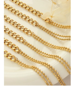 Detailed macro view of mixed Cuban link and double-layer beaded chain in 18k gold finish