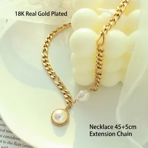 Vintage 18k gold plated stainless steel necklace with pearl pendant on a white ceramic plate