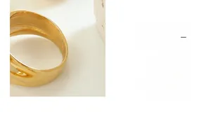 Detailed macro view of gold-plated wavy texture ring with polished mirror finish