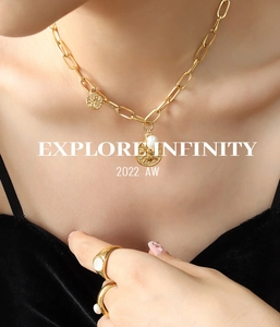 Detail of gold coin pendants with freshwater pearl on heavy chain worn by a model
