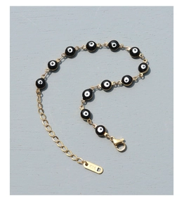 Dettaglio del bracciale occhio del diavolo in oro 18k con perline nere e chiusura a moschettone