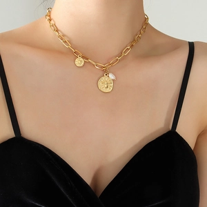 Gold paperclip chain necklace featuring a bee coin pendant and a teardrop pearl on model