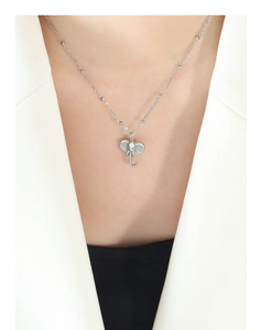 Close-up of a 3D elephant pendant necklace with textured detail on a white blazer
