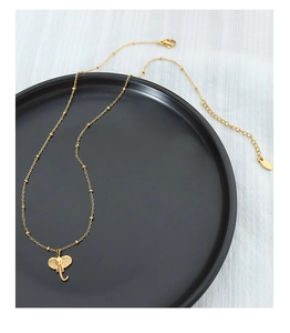 Detail of a 3D elephant pendant with bead chain and lobster clasp on a ceramic tray