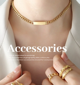 Detail view of 18k gold plated Cuban chain necklace and matching textured rings on a model