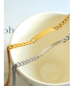 Detail of gold and silver curb chain bracelets with rectangular bar for engraving
