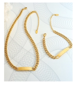 Close-up of gold geometric bar necklace and bracelet set with 18K engraved detail