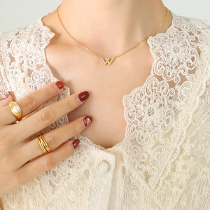 Goldenes W-Halsketten-Set mit Perlenringen an Model in Spitzenkleidung
