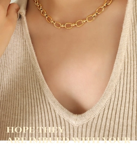 Gros plan d'un collier à grosses mailles en acier titane plaqué or 18 carats