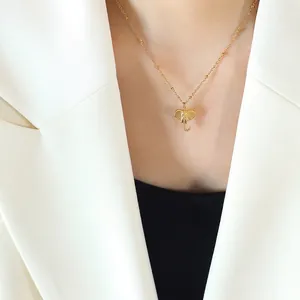 Minimalist gold-plated elephant pendant necklace with textured detail on a thin bead chain
