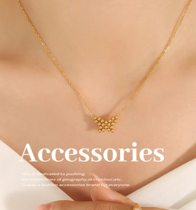 Detailed close-up of a golden butterfly necklace with beaded pendant on a model neck