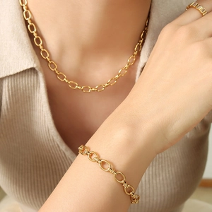 Parure de bijoux dorés avec collier à maillons ovales, bracelet et bague zircon