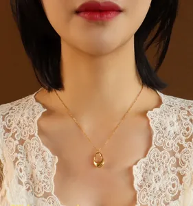 Detailed close-up of hollow water drop pendant in 18K gold finish on a fine chain