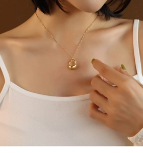 Close-up of sleek 18K gold plated necklace featuring an abstract irregular pendant