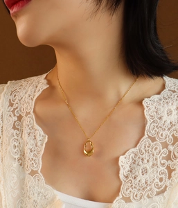 Close-up of vintage hollow irregular pendant on 18K gold plated titanium necklace