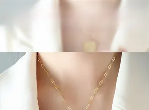 Detailed view of 18K gold plated paperclip link chain necklace on model collarbone