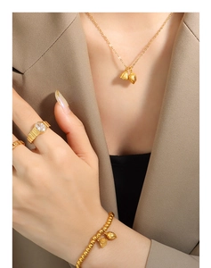 Detail of model wearing lotus-shaped gold jewelry set with necklace and stone ring
