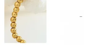 Close-up of 18K gold-plated beaded chain showing polished metallic luster and texture