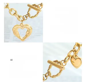 Macro detail of polished heart pendant and OT buckle on 18k gold plated titanium steel chain