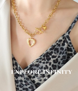 Close-up of gold chunky chain necklace with double heart pendants and OT toggle clasp