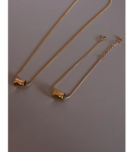 Detailed view of polished 18K gold-plated cylinder necklace and bracelet set