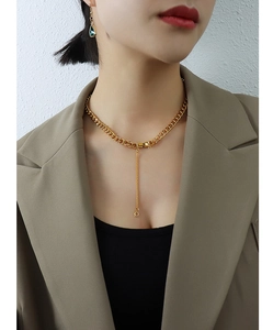 Primer plano de un collar de cadena gruesa dorada con detalle de borla en modelo