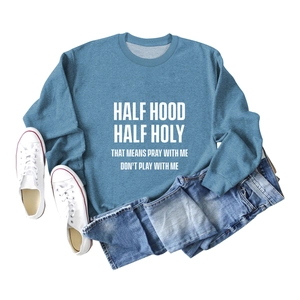 Détail du sweat à col rond bleu grisâtre avec texte HALF HOOD HALF HOLY et texture du tissu