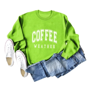 Flat lay of neon green sweatshirt with COFFEE WEATHER print and blue jeans